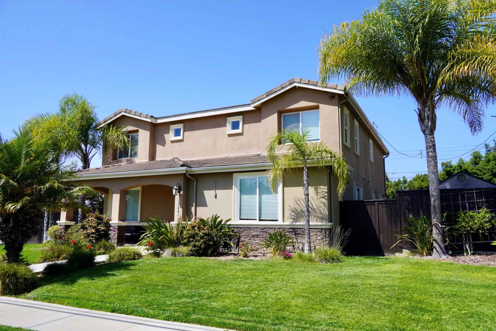 Photo of a Los Angeles sober living with green grass, palm trees, and flowers.